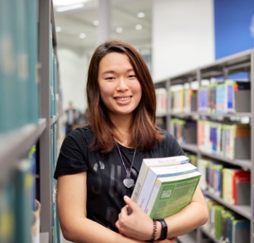 student hold books in library