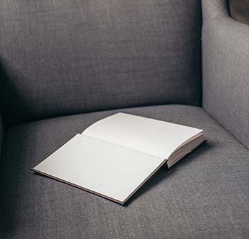 a book resting on a grey chair