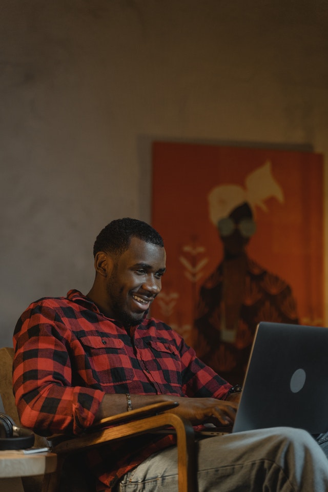 a man using a laptop and smiling