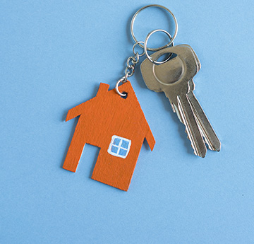 Set of keys with a house-shaped keyring on a blue background