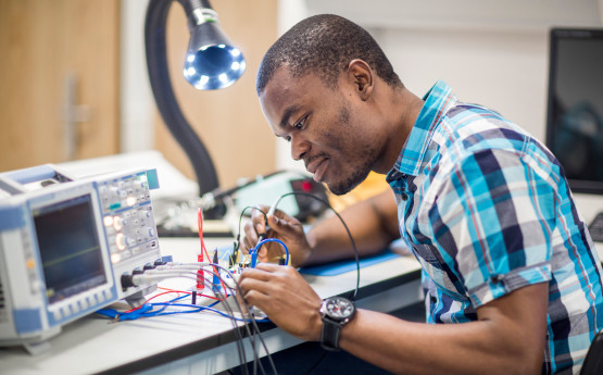 A male student working in an electronics lab