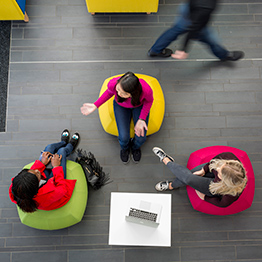 Three female students sitting on bean bags and talking