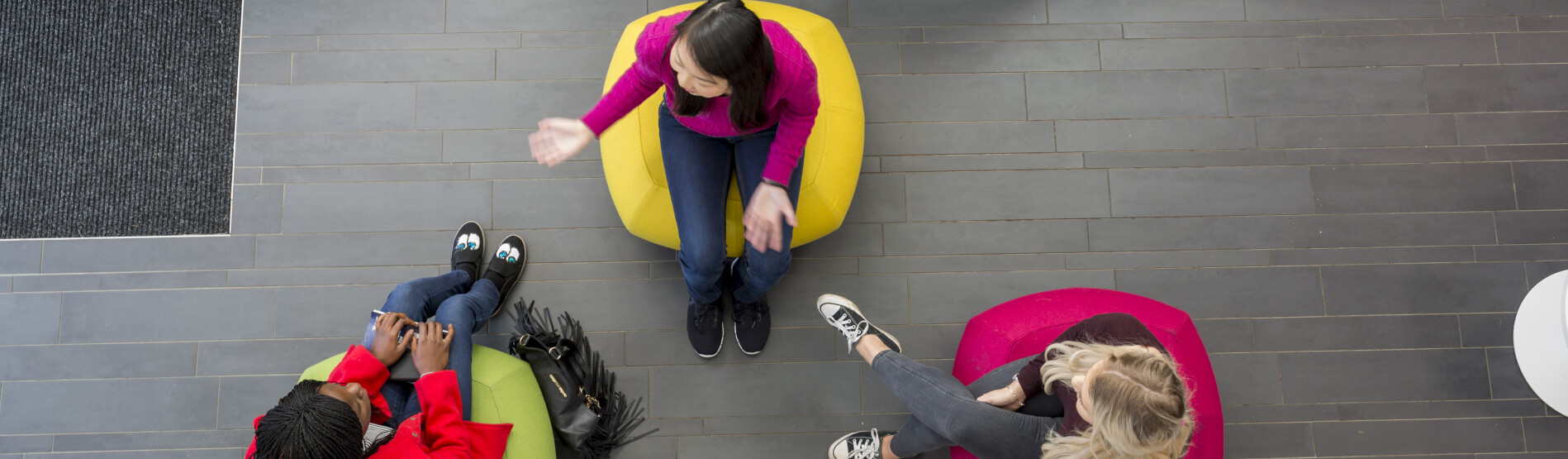 Students sitting on colourful chairs