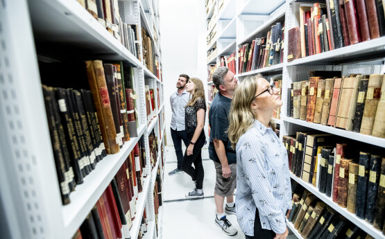 students looking at books in library