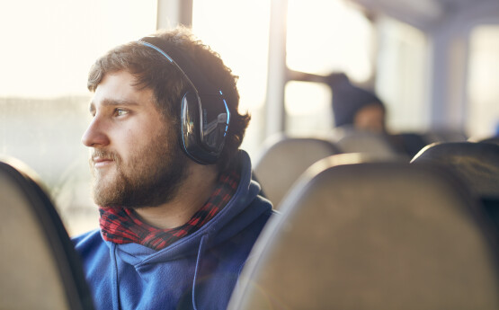 Man sitting on bus with headphones on