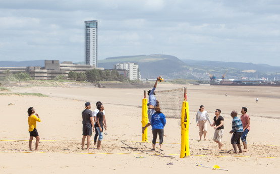 Students playing volleyball on the beach