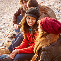 Group of students sitting on a pebble beach