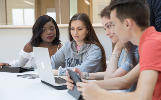 Four students looking at a laptop