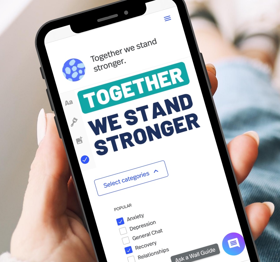 A hand holding a phone displaying the together all website stating, together we stand stronger.  